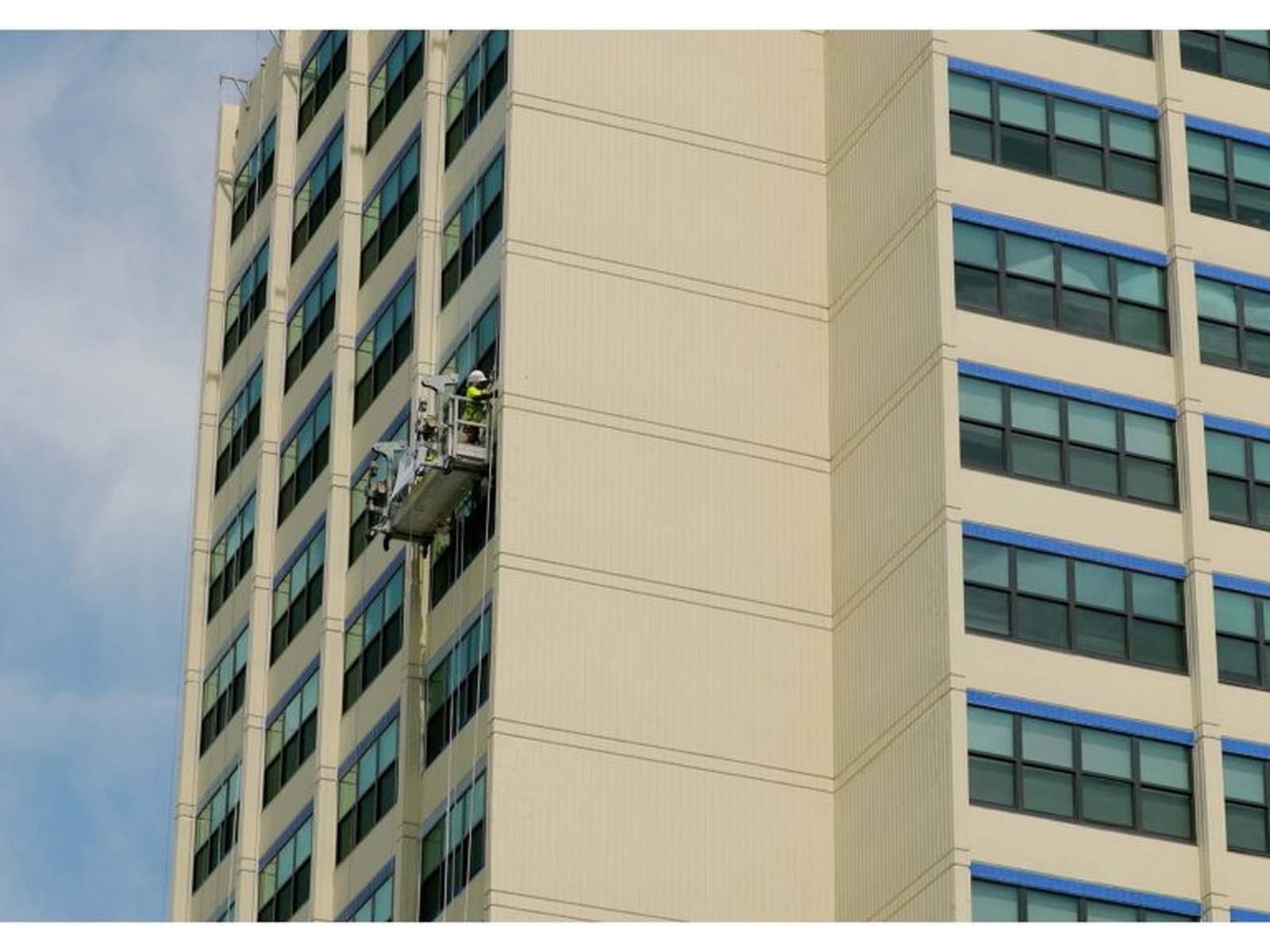 Crew on a boom lift coating a high-rise exterior